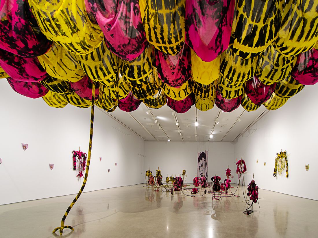 Installation of soft sculptures supported by bamboo structures extended with yarn to a large filet net with an embroidered portrait.