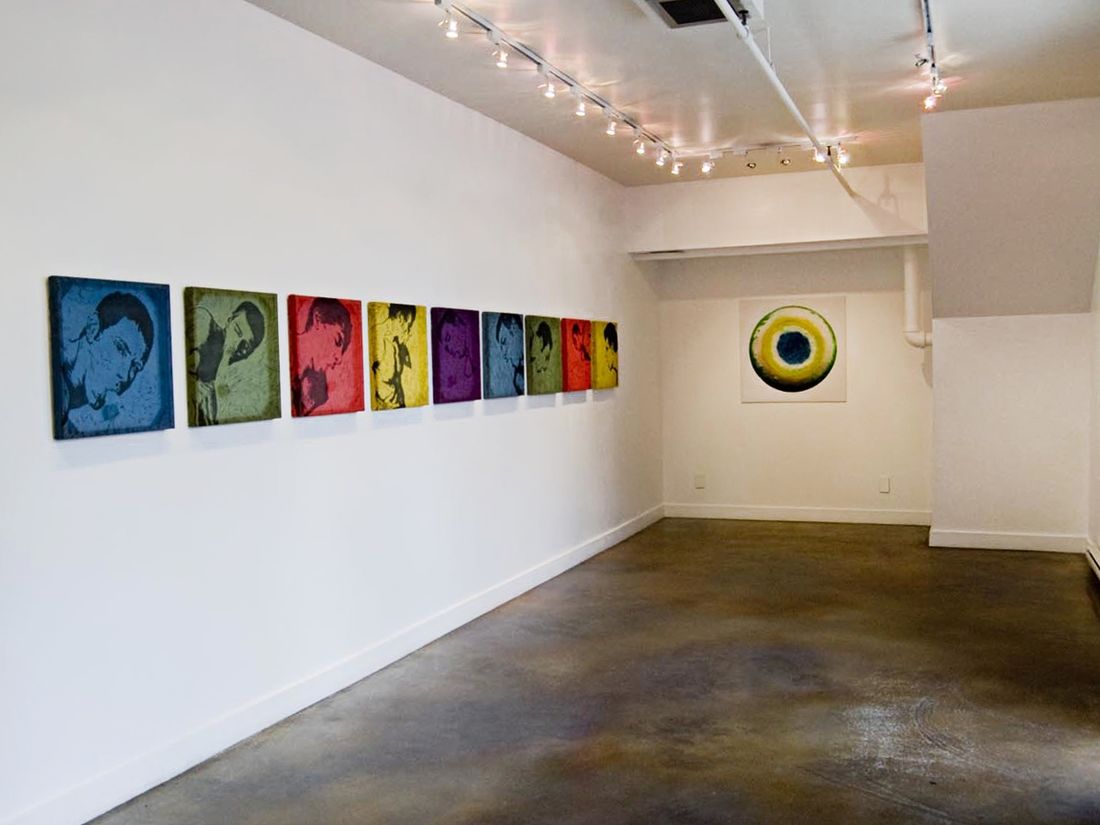 Installation shot of solo show consisting of woodcuts and one large photograph in primary colors.