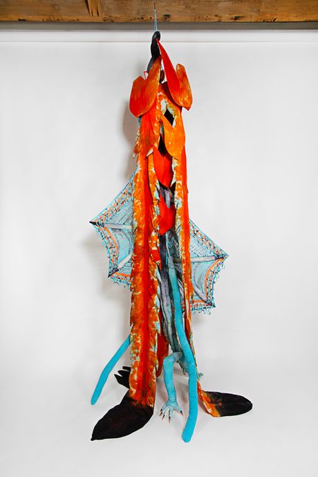 Hand-dyed primarily in bright orange and robin egg blue, this tall soft sculpture resembles a spadix plant with wide knitted wings.