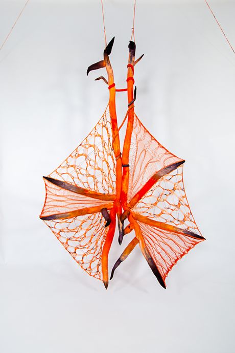 Hand dyed soft sculpture shaped in large bat-like wings where the membranes are knitted with beads.