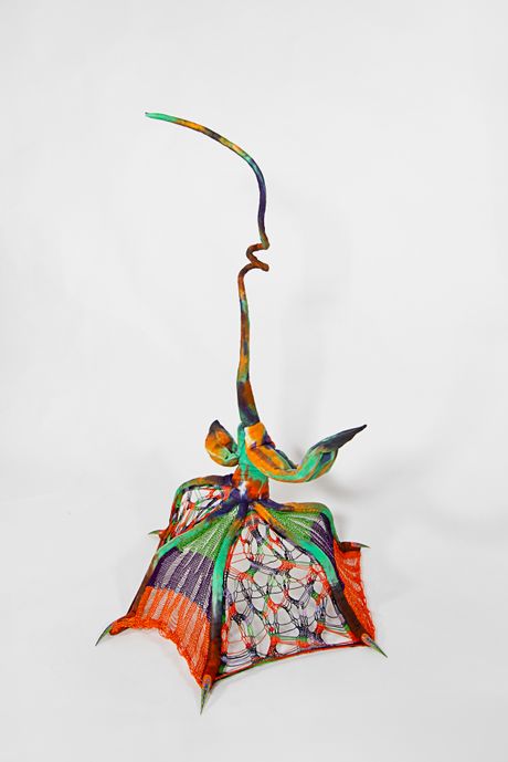 Hand dyed soft sculpture shaped like a budding plant with long webbed fingers, where the wings are knitted.