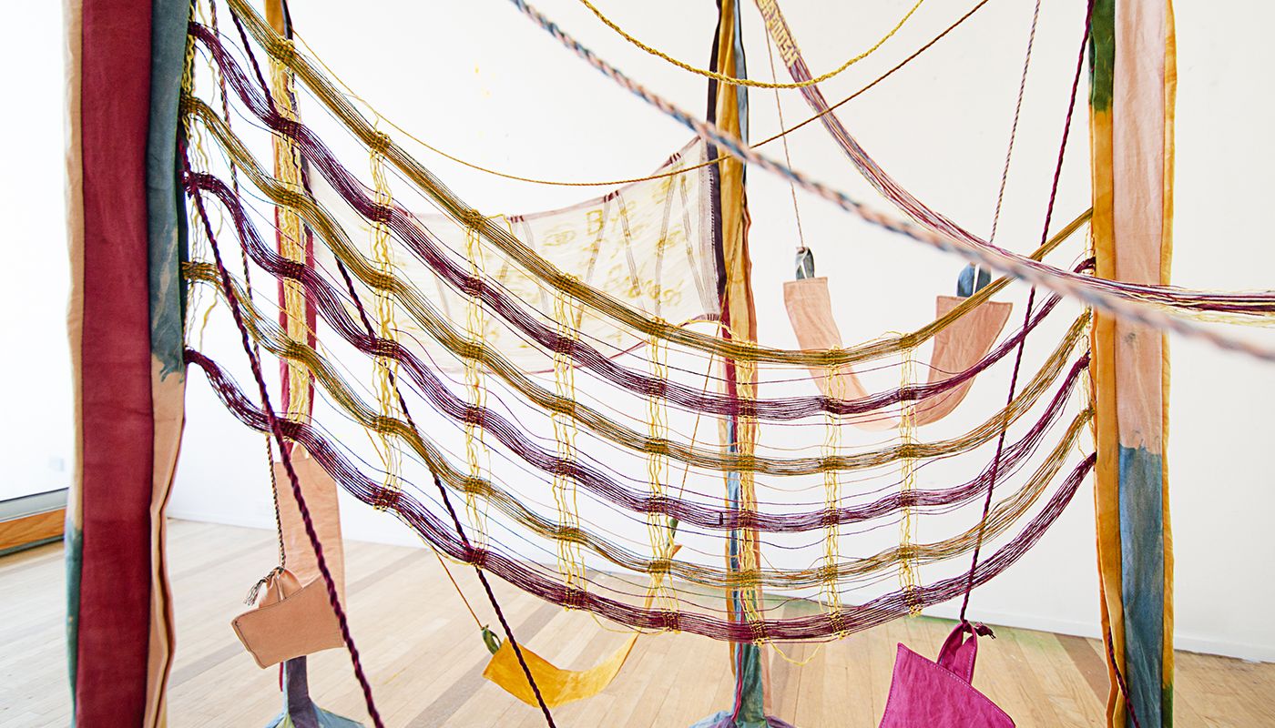 Colorful woven forms using backstrap weaving on fabric posts dyed with onion skins, indigo, avocado skins and pits, goldenrod, and sappanwood.
