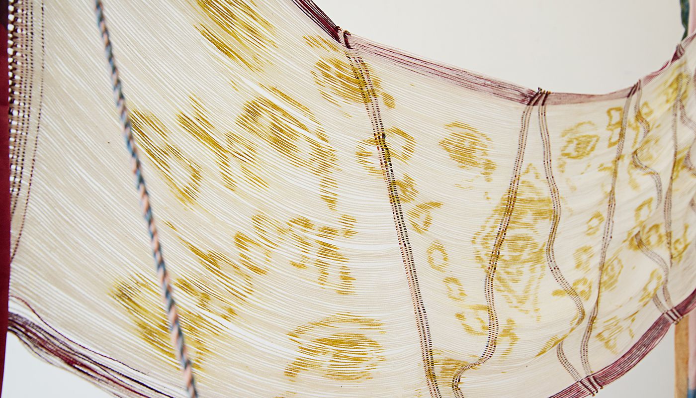Goldenrod paste applied to the warp of a backstrap weaving.