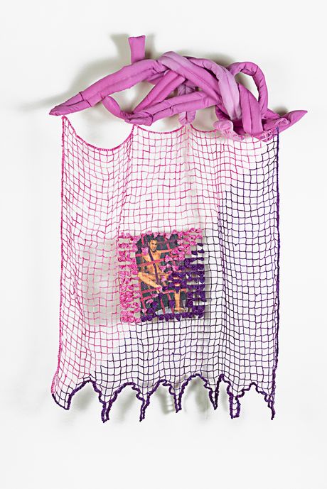 Wall sculpture in pink and purple. The top part is a soft sculpture shaped into several long pink tongues jumbled together. The bottom part is a rectangular filet lace with a detailed embroidered image in the middle that has been dye sublimated and then embellished with dimensional pointed stitches.